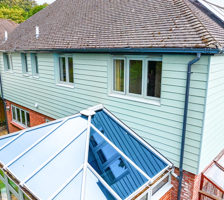 casement windows installation on a house with green cladding